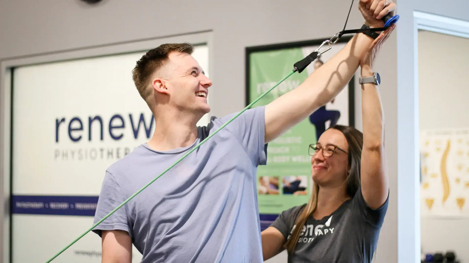 Young man performing a resistance band exercise with a Renew Physiotherapist