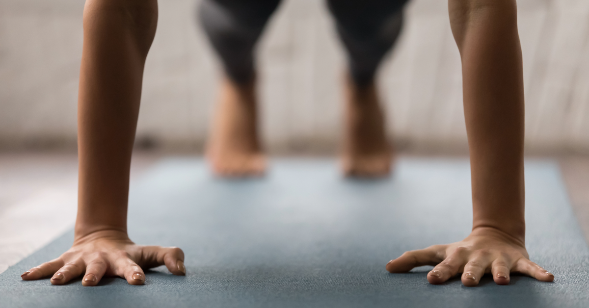 a woman doing a plank on a yoga mat 
