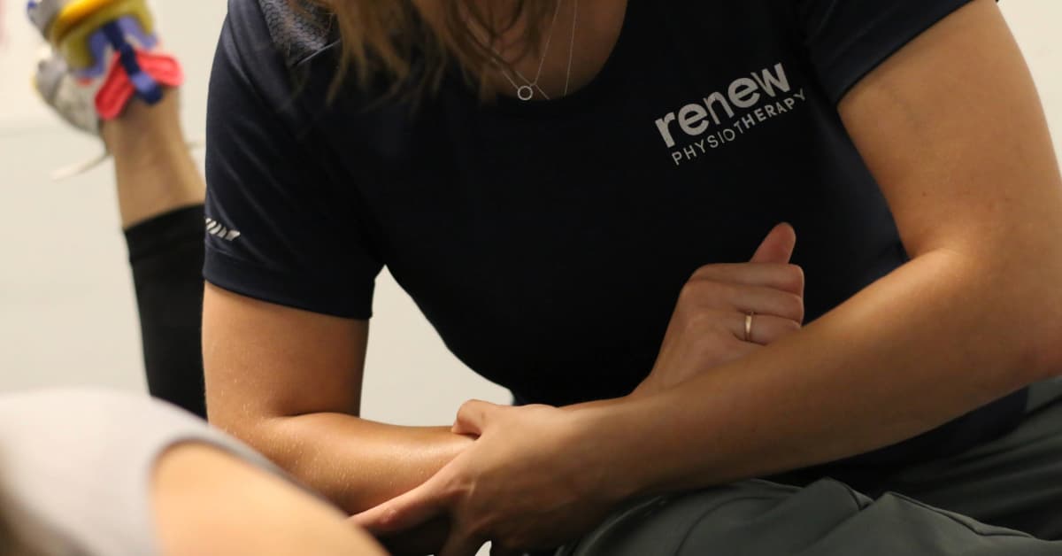 A physiotherapist practicing a hands on manual therapy on a patient's back with her elbow